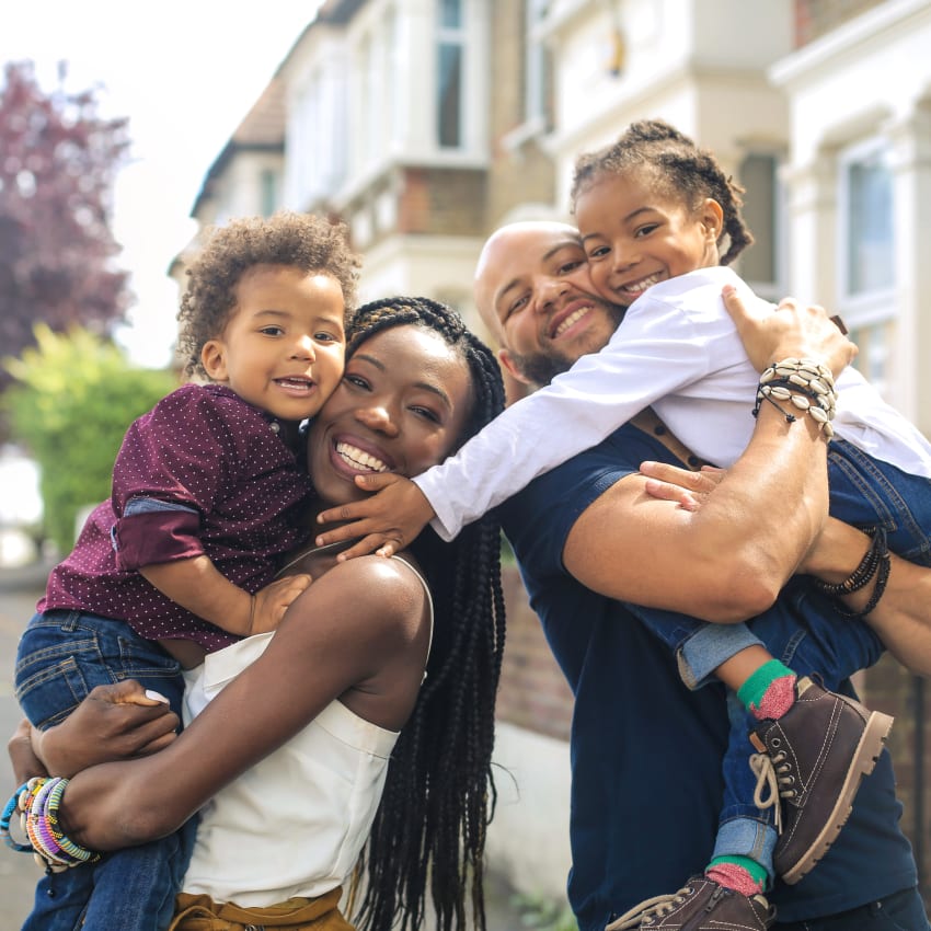 A mom, dad and young boy and girl pose for a family photo
